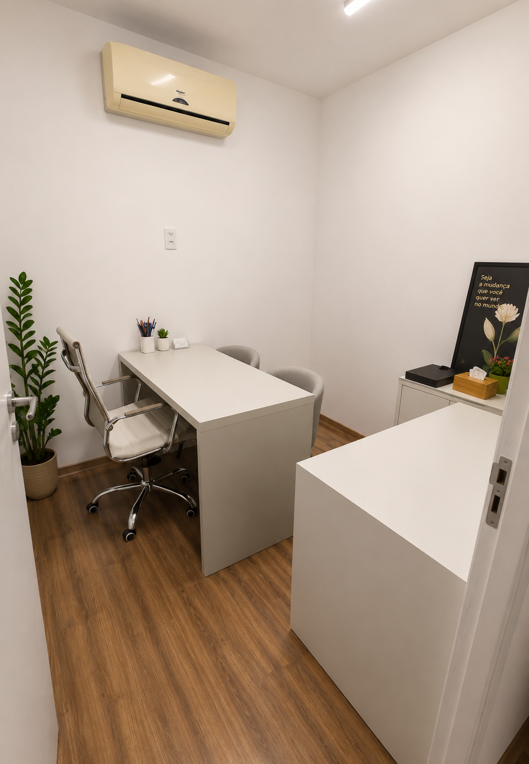 Consultório 01 do Instituto Axon Savant com mesa de atendimento, cadeiras e ar-condicionado.