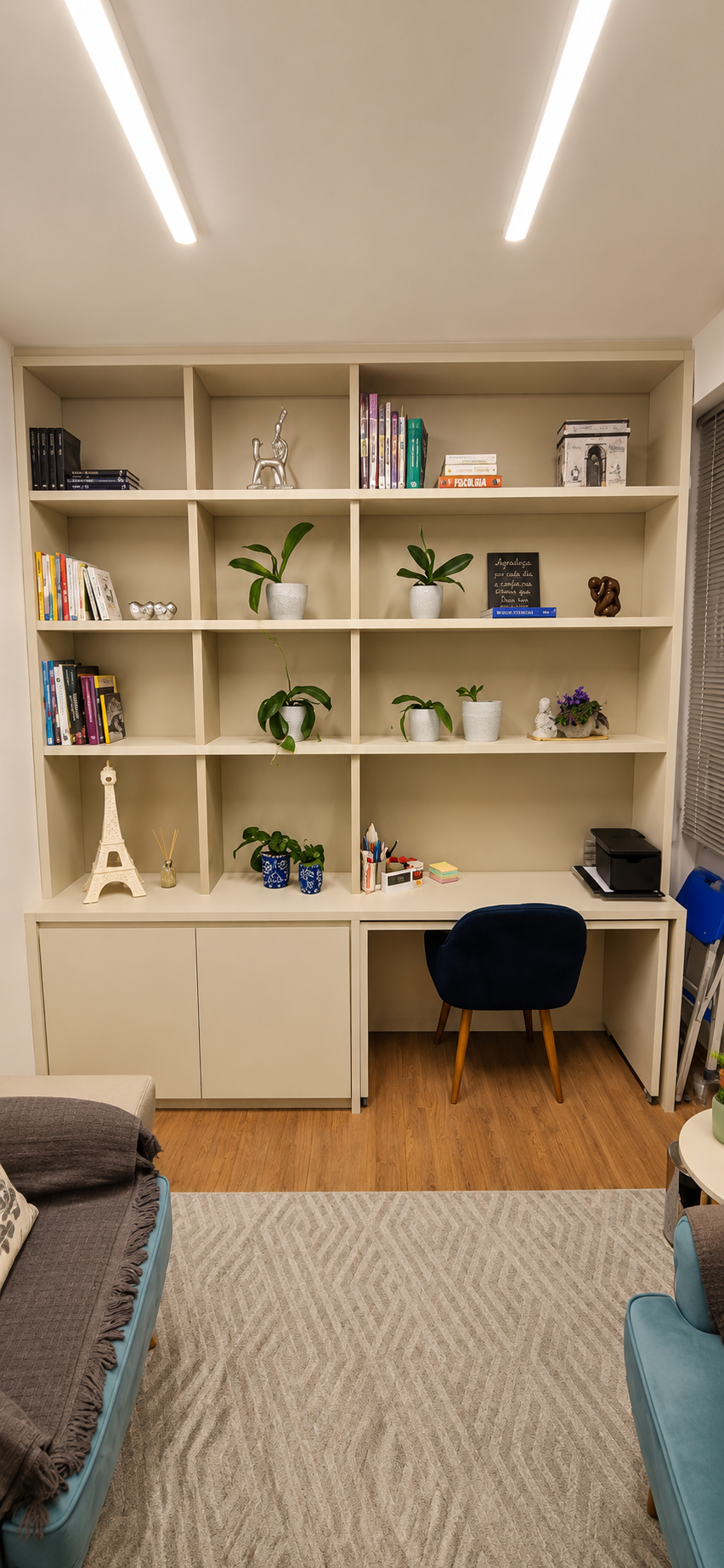 Consultório 02 do Instituto Axon Savant com estante, livros, plantas e área de atendimento.