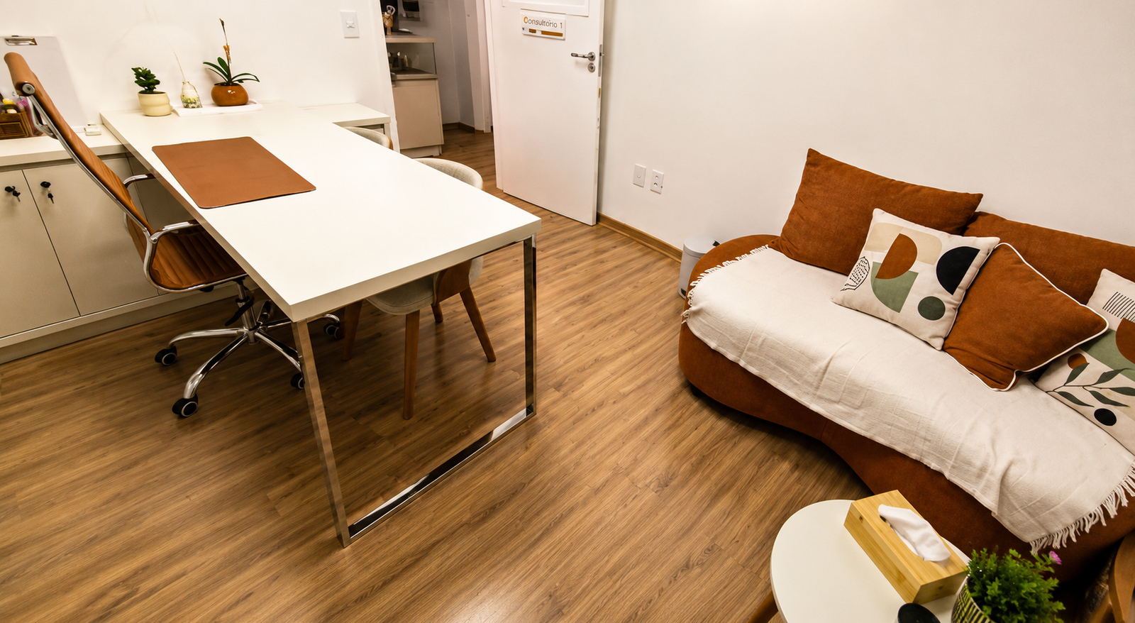 Consultório 03 do Instituto Axon Savant com mesa de atendimento, sofá e ambiente amplo.
